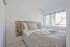 a white bedroom with a large bed with towels on it at Bob W Oslo Gamle in Oslo