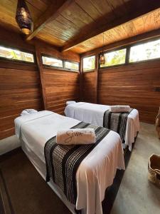 2 camas en una habitación con paredes y ventanas de madera en Siwa Tulum en Tulum