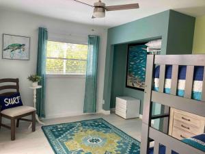 a bedroom with a bunk bed and a chair at Stylish & Cheerful Marco Home w/ Awesome Location in Marco Island