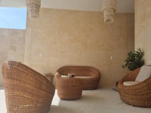 two wicker chairs and a table in a room at Villas Bliss 18 in Isla Mujeres