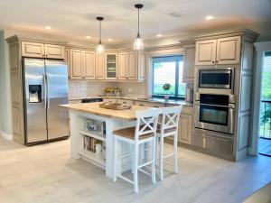 a kitchen with a white island and a refrigerator at Stylish & Cheerful Marco Home w/ Awesome Location in Marco Island
