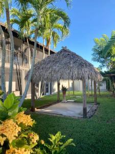 una cabaña de paja frente a un edificio con palmeras en Stylish & Cheerful Marco Home w/ Awesome Location, en Marco Island