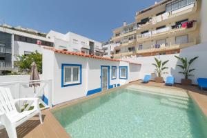 a swimming pool in front of a building at Pátio C'un Casinhas in Nazaré