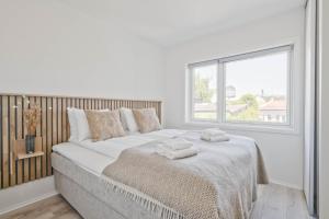 a white bedroom with a large bed with towels on it at Bob W Oslo Gamle in Oslo