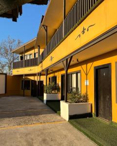 un bâtiment jaune avec un parking devant lui dans l'établissement Hotel Coronado, à Ensenada