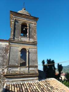 een oude klokkentoren bovenop een gebouw bij Appartamento nel centro storico di Caulonia in Caulonia