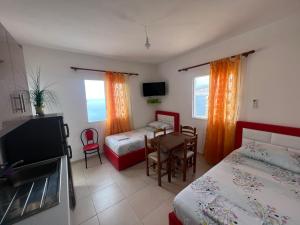 1 dormitorio con 2 camas, mesa y sillas en Prive Hill Saranda en Sarandë