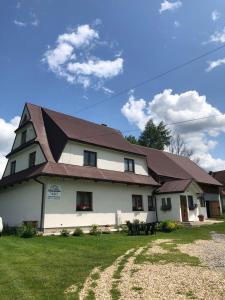 a large white house with a brown roof at Cichy Zakątek in Ciche