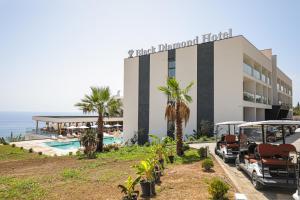 a hotel with two golf carts parked in front of it at Black Diamond Hotel Dhermi in Dhërmi