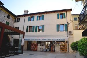 un bâtiment avec un magasin sur son côté dans l'établissement Casa Narciso, à Lazise