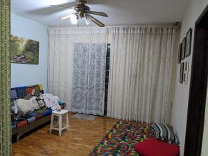 sala de estar con sofá y ventilador de techo en Casa inteira e quartos individuais!, en Belo Horizonte