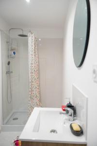 y baño blanco con lavabo y ducha. en YELLOW HOME, en Fougères
