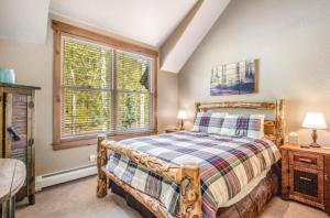 1 dormitorio con cama de madera y ventana en Lovely Townhome A Half-mile From Keystone Gondola W-shared Hot-tub Excellent Views, en Dillon