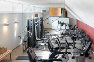 a gym with a bunch of treadms and cardio machines at Landhotel 3Kronen in Adelsdorf