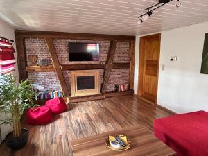 a living room with a fireplace and a tv on a brick wall at FeWo Marie im Ferienhaus Selma in zentraler Lage in Großschönau