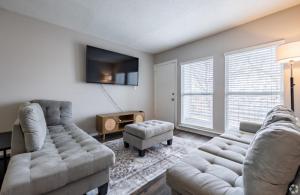 a living room with two couches and a tv at The Avery in Atlanta