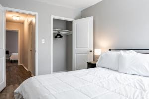 a white bedroom with a white bed and a door at The Avery in Atlanta