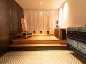 una habitación con una silla sentada en las escaleras en Showcase Hotel KASANE, en Gotsu