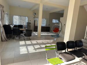 a large living room with a table and chairs at Kams Lodge Broadview, Idu in Furah