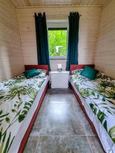 two beds in a room with a window at Kolonijna Park in Międzyzdroje