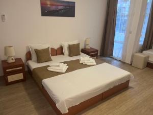 a bedroom with a large bed and two night stands at Хотел CANAVAN'S - beach in 2 minutes, free parking and WiFi in Ravda