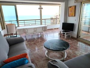 salon z kanapą i stołem w obiekcie 1 min a pie Playa San Juan. Increíbles vistas al mar. Urbanización con piscina, padel y tenis. w Alicante