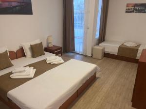 a bedroom with a large bed with towels on it at Хотел CANAVAN'S - beach in 2 minutes, free parking and WiFi in Ravda +139 photos
