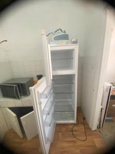 an open door to a kitchen with an empty shelf at Appartement Corniche Nador in Nador