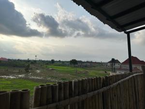 a wooden fence with a field in the background at Kams Lodge Broadview, Idu in Furah