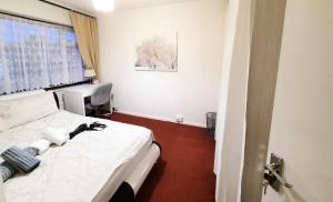 una camera d'albergo con letto e finestra di London North Downs rooms a Londra