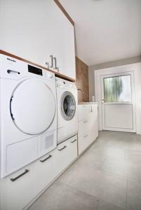 een witte wasruimte met een wasmachine en een raam bij Ruhige, moderne Villa im Grünen 