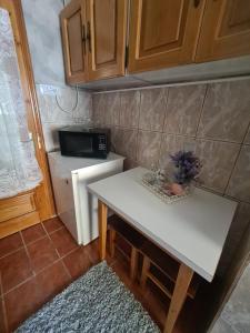 una pequeña cocina con mesa blanca y microondas en Garsoniera Slanic-Moldova, en Slănic-Moldova