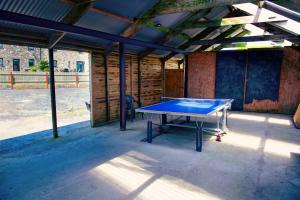 a ping pong table sitting inside of a building at The Big Cwtch Shepherd's Hut in Kidwelly