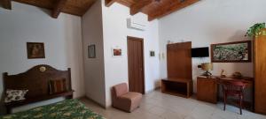 ein Schlafzimmer mit einem Bett, einem Stuhl und einem Schreibtisch in der Unterkunft Masseria Milu' in Siponto