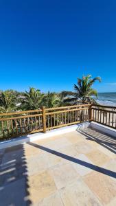 a balcony with a fence and the beach at Villa Continentes Brasil & Maison de rêve sur la plage in Guajiru