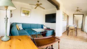 a living room with a blue couch and a table at Casa Junto al Mar in La Herradura