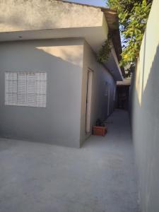 - un bâtiment blanc avec une fenêtre et une porte dans l'établissement CANTINHO DA PRAIA, à Mongaguá