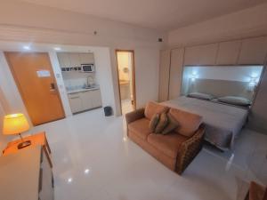 a large bedroom with a bed and a couch at Tropical Executive Vista Ponta Negra in Manaus
