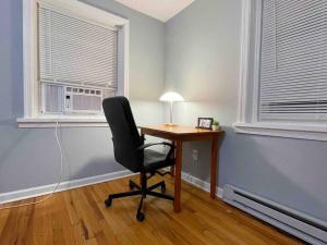 a desk with a chair in a room with two windows at THE ECO HOME. Entire place with private parking in Wilmington
