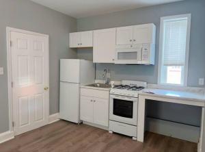 a kitchen with white cabinets and a white stove and refrigerator at THE ECO HOME. Entire place with private parking in Wilmington