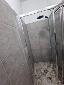y baño con ducha y puerta de cristal. en Obiteljski stan Kaštel Lukšić, en Kaštela