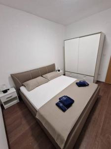 1 dormitorio con 1 cama grande y 2 toallas azules en Obiteljski stan Kaštel Lukšić, en Kaštela