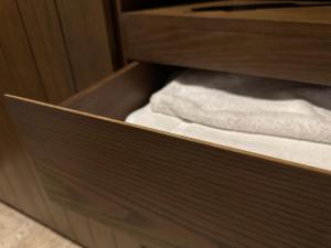 un cajón de madera con toallas blancas en un armario en Ophelia Tulum Condo Hotel in Aldea Zama, en Tulum