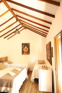 Habitación con 2 camas y una pintura en la pared. en Pousada Estrela do Mar en Caraíva