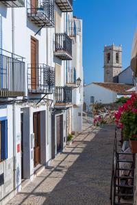 une rue dans une ville avec des bâtiments blancs et une tour d'horloge dans l'établissement Apartamentos Terramar, à Peñíscola