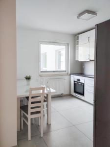 eine Küche mit einem Tisch und Stühlen sowie einem Fenster in der Unterkunft Apartment Szwed-Sniadowskiej Residence in Krakau