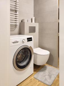 uma casa de banho com uma máquina de lavar roupa e um WC em Apartment Szwed-Sniadowskiej Residence na Cracóvia