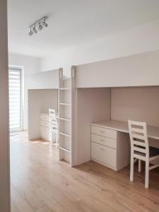 een slaapkamer met een bureau en een bed met 2 stoelen bij Apartment Szwed-Sniadowskiej Residence in Krakau