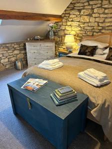 a bedroom with two beds and a stone wall at Siam cottage guesthouse over 300 years old with Thai restaurant in Moreton in Marsh