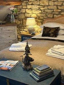 een slaapkamer met 2 bedden en een tafel met boeken bij Siam cottage guesthouse over 300 years old with Thai restaurant in Moreton in Marsh
